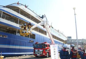 屈折式はしご車でフェリー甲板上の乗客を救出する訓練=5月9日、佐渡市両津湊
