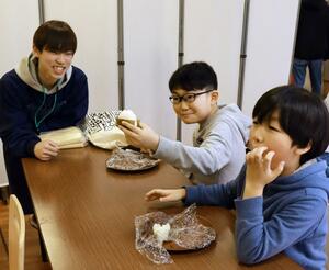 子ども食堂を訪れ、地域の子どもたちと新大コシのおにぎり作りを楽しむ「こめくしょん」の学生たち=新潟市東区下木戸1