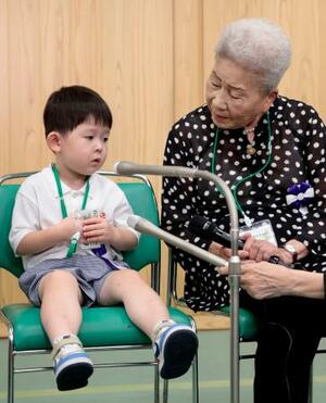 全国戦没者追悼式を前に取材に応じる最年少参列者の片山純矢ちゃん。右は曽祖母の伊藤早苗さん=15日午前10時21分、東京・日本武道館