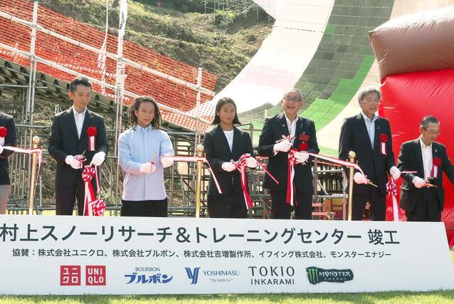施設の完成を記念し、平野歩夢（右から５人目）、平野海祝（右から４人目）両選手の兄弟らがテープカットした＝９月１４日、村上市瀬波温泉３