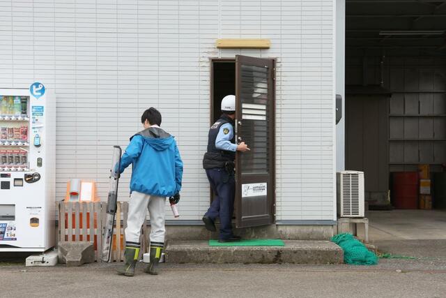 
クマが立てこもった阿賀野市の建設会社に入る警察官＝３１日正午すぎ、阿賀野市新保
