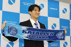 Ｊ２富山の応援グッズを掲げる新潟経営大のＤＦ丸山嵩大