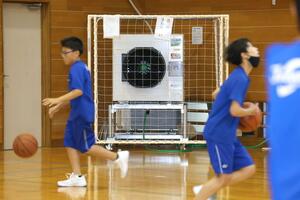 燕中の体育館に設置されたスポットエアコン。複数の大型扇風機と共に使用して生徒を熱中症から守っている＝７月上旬、燕市