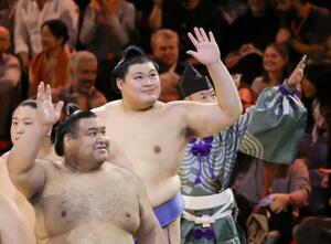 閉会式を終えて手を振り引き揚げる横綱大の里(中央)ら=19日、ロンドン(共同)