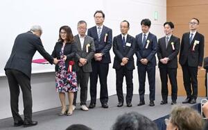 日本写真協会賞の表彰式で、学芸賞の賞状を受け取る中国新聞社の金崎由美特別編集委員(左から2人目)と報道各社の代表者=1日午後、東京都内