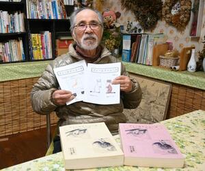 野生生物の情報誌「フィールドニュース」を手にする野紫木洋さん=2024年11月、糸魚川市青海