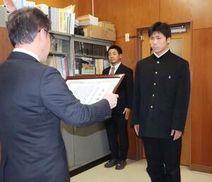 表彰状を受け取る六日町高校野球部の小谷航琉主将(右)