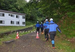 15日午前、閉鎖された羅臼岳の登山口から入山する捜索隊=北海道斜里町