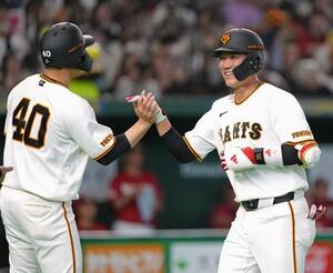 　６回、２ランを放ち、中山（左）とタッチを交わす巨人・坂本＝東京ドーム