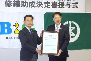 プール改修の助成決定書を中原八一市長に手渡すB&G財団の朝日田智昭常務理事(左)=新潟市役所