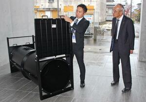 ドラム式わなを寄贈した新和商事の櫻井貫社長(右)=魚沼市役所