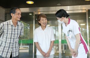 認知症薬「レカネマブ」の投与治療を終え病院を出る女性患者(中央)=7月31日、柏崎市
