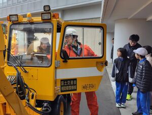 除雪機に乗車し操作を学ぶ児童たち=湯沢町神立