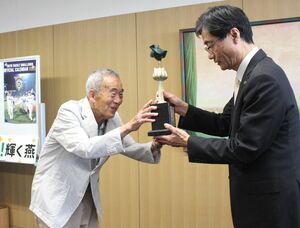 鈴木力市長(右)にトロフィーを手渡す宇佐美彰朗さん=燕市役所