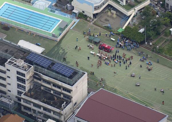 火災があった東京都北区立滝野川第三小で消火活動に当たる消防隊員ら＝１９日午前１１時５２分（共同通信社ヘリから）