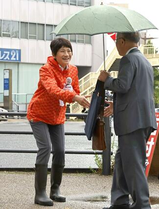 通勤者らと握手する西村智奈美さん＝新潟市中央区