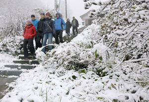 雪が積もる温泉街を歩く外国人観光客=7日午前9時過ぎ、妙高市関山の燕温泉