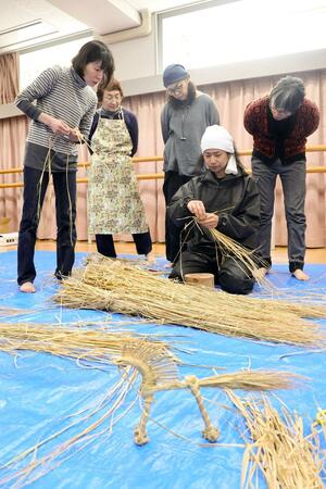 飛天双○能の関連イベントで、わら細工の絞張馬を作る参加者ら＝５日、佐渡市中原