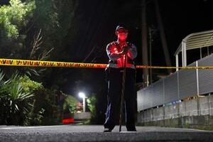 強盗殺人事件のあった現場周辺で警戒にあたる警察官=26日午後10時54分、佐賀県伊万里市
