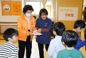 「命のアサガオ」の種を児童に手渡した丹後まみこさん=胎内市江上