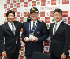 指名あいさつ後、王貞治会長らのサインボールを持ち、笑顔を見せる池田栞太（中央）＝上越市