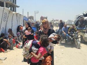 10日、パレスチナ自治区ガザ南部ハンユニスで、イスラエル軍の地上侵攻拡大を受けて避難するパレスチナ人の家族(ゲッティ=共同)