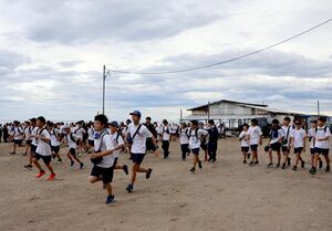 がんばり行軍で一斉にスタートする直江津中の生徒たち=10月23日、上越市の郷津海岸