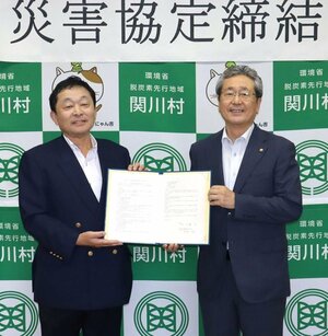 災害時のごみ処理に関する協定を締結した県産業資源循環協会新発田支部の曽根剛支部長(左)と関川村の加藤弘村長=関川村役場