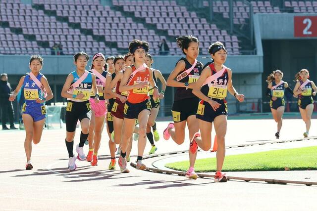 女子　序盤好位置につける新潟明訓（１１）、新潟第一（１２）の１区選手＝ビッグスワン