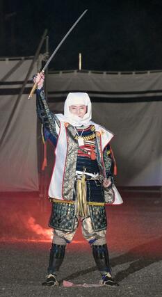 謙信公祭の「川中島合戦の再現」で、戦いが終わり、義の心の大切さを説き、「えいえいおー」と太刀を掲げる上杉謙信役の越乃リュウさん＝２４日、上越市大豆の春日山城史跡広場