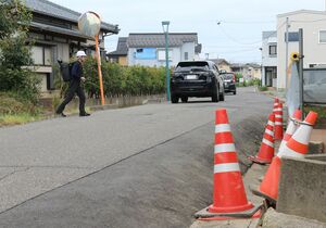 側方流動の影響で隆起したとみられる市道。長岡技術科学大などが調べている=8月下旬、新潟市西区鳥原