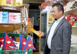 経営する香辛料店で商品を手に取る鈴木ジョー社長=9日、東京都豊島区