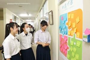 「逃げる」ことについての考えや体験談が書かれた掲示を見る新潟東高校の生徒=新潟市東区小金町