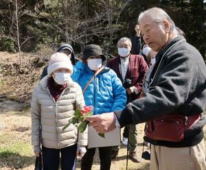 武井勇さんから花の解説を聞く参加者=佐渡市羽茂飯岡
