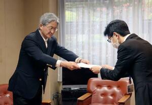 抗議文を提出する市民団体「教科書問題を考える市民ネットワーク・ひろしま」の岸直人さん(左)=17日午後、広島市