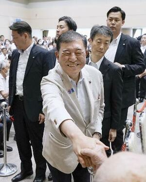 警戒するSP(警護官)らに囲まれ、支援者と笑顔で握手をする自民党総裁の石破首相=5日、新潟県長岡市
