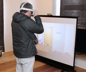 ＶＲで震度６弱の揺れを体験する来場者＝２５日、長岡市古正寺２
