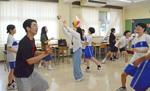 紙風船やけん玉などを一緒に楽しむ韓国の高校生と津南中等教育学校の4年生=津南町下船渡