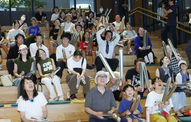 スクリーン越しに声援を送る市民ら=13日、長岡市大手通2