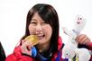 女子ビッグエアで獲得した金メダルをかじるポーズで笑顔の村瀬心椛＝リビーニョ（共同）