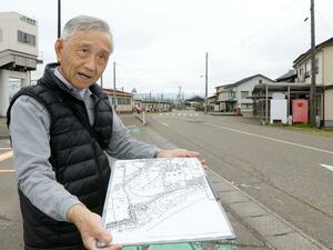 地図を手に、直江津空襲で爆弾が投下された地点を説明する田辺松蔵さん=上越市黒井