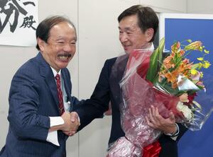 後援会長を務めた石田誠夫さん(左)と当選後に喜びを分かち合う小菅淳一さん=26日、上越市藤巻