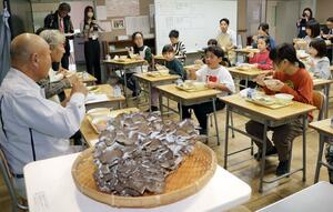薬師まいたけ(手前)を使った給食を味わう七谷小児童と生産者ら=加茂市下高柳