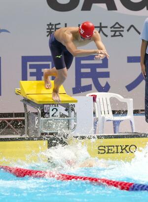 成年男子200メートルリレー決勝 第2泳者の樋口陽太から第3泳者の頓所拓海につなぐ=佐賀市