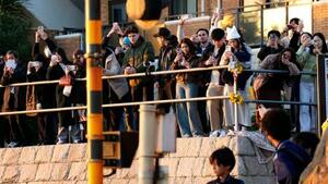 　神奈川県鎌倉市の踏切で写真を撮る人たち＝１７日午後