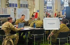 軍民調整センターで話し合う米兵=19日、イスラエル中部キリヤトガト(共同)