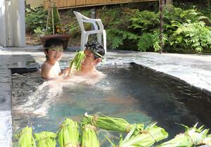 花の湯館のしょうぶ湯。親子連れらがショウブの束が浮かぶ湯に漬かった=5月5日、新潟市秋葉区天ケ沢