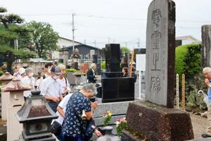 藤岡事件の慰霊祭で、慰霊碑に手を合わせる参列者=13日午後、群馬県藤岡市