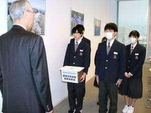 集めた義援金を市に託す猿橋中学校の生徒たち=新発田市役所