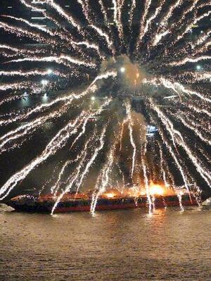 横浜市で開かれていた花火大会で炎上する海上の台船=4日夜